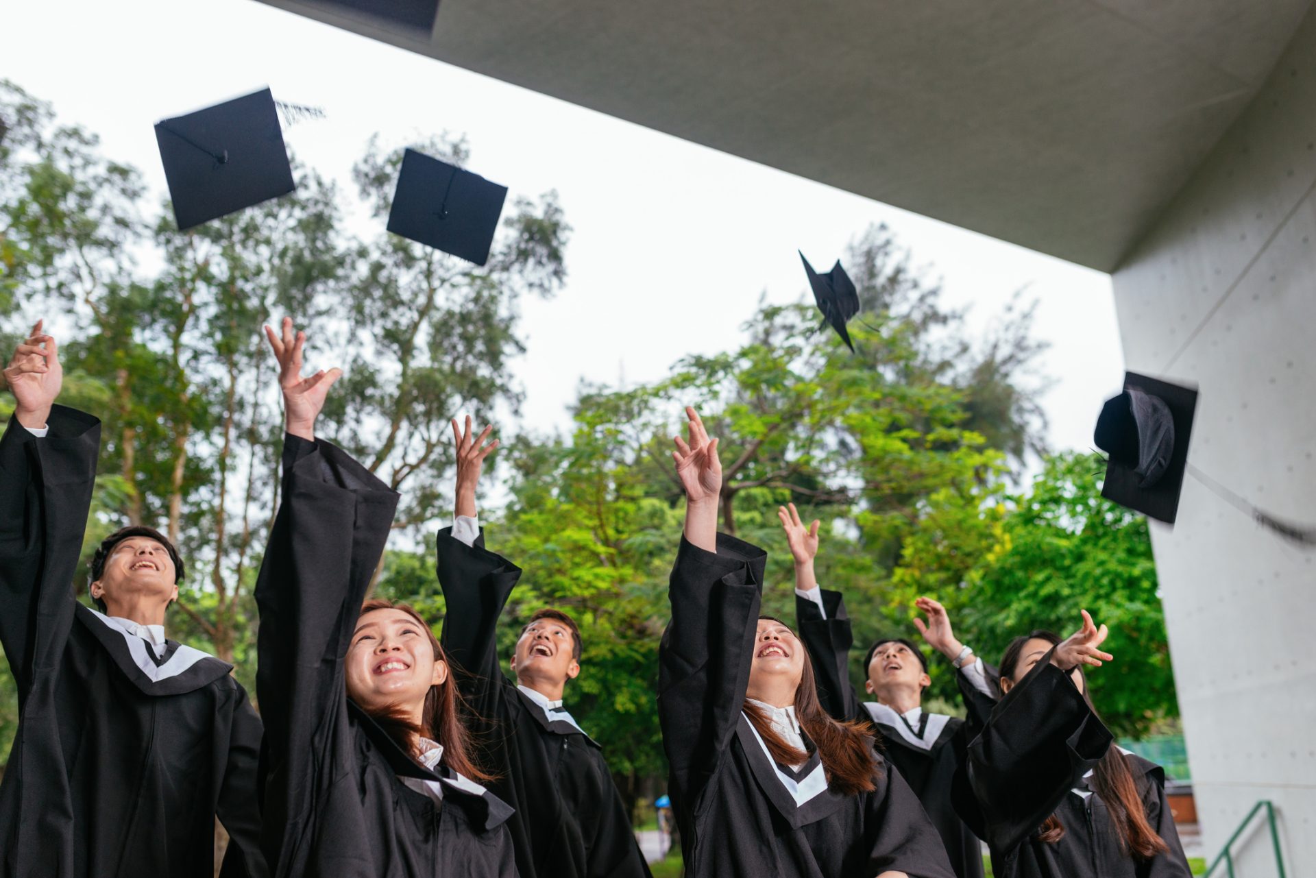 Students on graduation ceremony throwing caps in the air