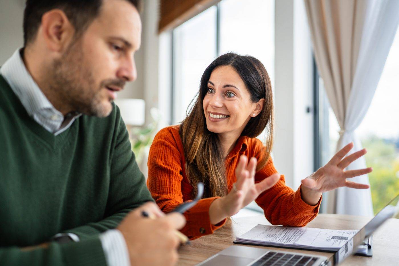 A couple talking face to face over a laptop at home